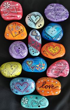 painted rocks with the words love written on them are arranged in a heart - shaped arrangement