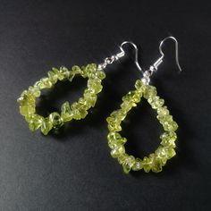 "Earrings measure about 2.5\" and are lightweight and easy to wear. Handmade from genuine peridot gemstone chips with silver plated stainless steel fishhook ear wires, chosen for their strength and hypoallergenic qualities. Peridot is a crystal of positive power, a talisman for recognizing and honoring the Creator's frequency of Love, the source of all abundance. Used with right intent, it helps expand one's ability to receive from the Universe on all levels of life. As gems can vary in color an Fluorite Earrings, Fluorite Jewelry, Shaped Hoop Earrings, Silver Wire Earrings, Bead Woven Bracelet, Beaded Bangles Bracelets, Peridot Earrings, Nature Earrings, Minimal Earrings