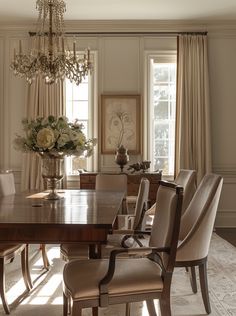 an elegant dining room with chandelier, chairs, and table in front of windows