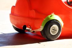 an orange toy car sitting on the ground