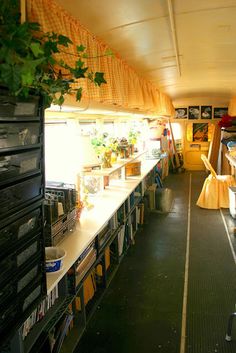 the inside of a bus with many items on the tables and shelves in front of it