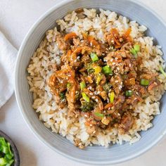 a bowl filled with rice and meat on top of a table