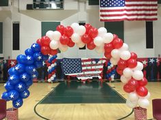 an american flag arch with red, white and blue balloons