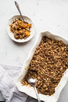 two bowls filled with granola next to each other on top of a white table