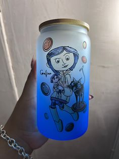 a hand holding a blue lite up jar with a drawing on the front and bottom