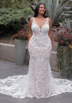 a woman in a white wedding dress standing on a patio with cacti and succulents behind her