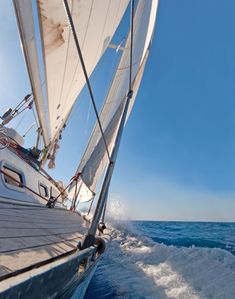 a sailboat sailing in the ocean on a sunny day