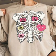 a woman wearing a skeleton shirt with pink heart balloons on her chest and the words you got