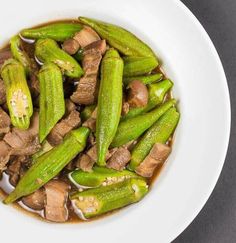 a white bowl filled with meat and green beans