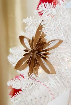 an origami star on top of a white christmas tree