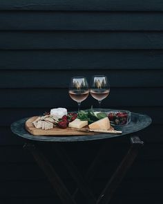 two glasses of wine and cheese on a table