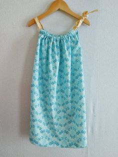 a blue dress hanging on a wooden hanger