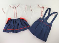 This classic stylish two-piece set includes a short-sleeve shirt elaborated in white Swiss dotted plumeti cotton. It features a nacar button front closure, a Peter Pan collar, and red rickrack trimmings. The suspender shorts are elaborated in a navy-blue pique cotton fabric with button side closures, elasticized pleated waistband and legs on the rear. Shorts feature a relaxed straight fit front waistband with a tuck on either side, red rickrack trimmings or red buttons, accomplish a dapper look. Summer School Cotton Sets, Summer Cotton School Sets, Fitted Summer School Sets, Cotton School Uniform Sets, Summer School Sets With Short Sleeves, Preppy School Sets For Spring, Navy Cotton Sets For Spring, Preppy Cotton School Sets, Preppy Cotton Sets For Spring