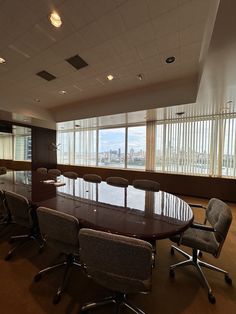 an empty conference room with large windows overlooking the city