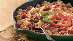 a skillet filled with rice, meat and peppers