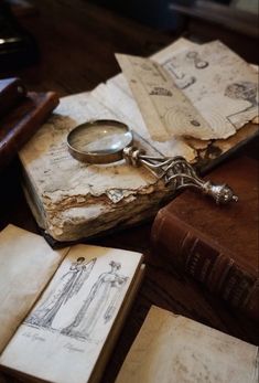 an old book and magnifying glass sitting on top of each other next to some books