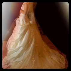 a woman in a wedding dress is standing on a bed with her back turned to the camera