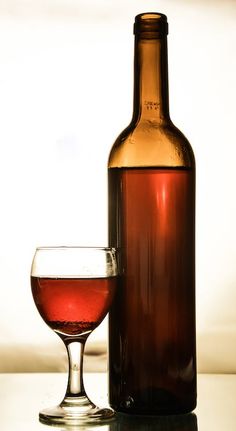 a wine glass and bottle sitting on a table