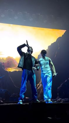 two men are standing on stage with their hands in the air and one is holding his head