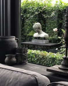 a living room filled with lots of furniture and vases on top of a window sill