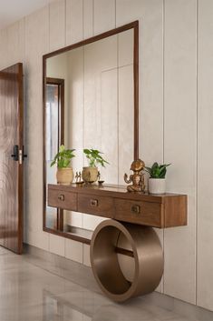 a mirror sitting on top of a wooden table next to a vase and potted plant