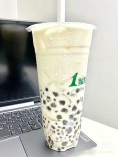 a drink sitting on top of a laptop computer