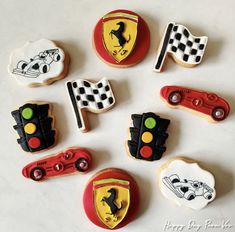 decorated cookies are arranged in the shape of cars and race flags on a white surface