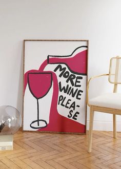 there is a wine glass on the floor next to a chair and a framed poster