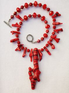 This necklace is FIERCE!! It makes quite a STATEMENT!! This CORAL is STUNNING!! It is real coral (probably dyed). The coral centerpiece is approx. 4 inches long. I gave this incredible piece of coral a necklace of smaller red coral pieces, faceted red Czech glass beads and small pewter silver spacer beads. This necklace is 19 inches long including the high grade, nickel and cadmium free toggle clasp. The last 2 photos posted show both sides of the coral pendant. One of a Kind Red Coral Hand-strung Necklace, Unique Hand-strung Red Coral Necklaces, Coral Centerpieces, Red Coral Necklace, Fish Necklace, Bali Silver, Bone Pendant, Coral Pendant, Red Necklace