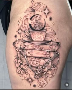 a woman's thigh with books and a coffee cup on top of her leg