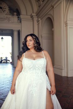 a woman in a white dress posing for the camera