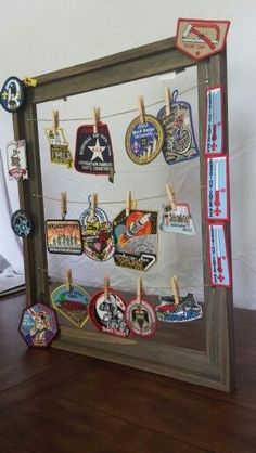 there is a wooden frame with many badges on it