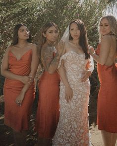 the bridesmaids are wearing orange dresses and one is holding her hand on her hip