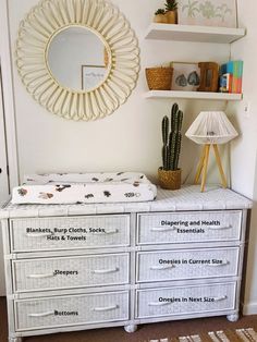 a white dresser with drawers and a mirror above it