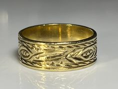 "Lovely antique wide gold band in solid 18K yellow gold. This beautiful antique ring measures 6.2mm north to south and is hand engraved on the outside with what appears to be a hand tooled floral theme. The band has a lovely patina and is in excellent condition. The age of this band is unknown. Ring size 5 1/4 and easily sized up or down several sizes. All hallmarks and patterns carefully preserved during sizing or restoration. Please allow three business days for sizing. One month layaway payme Victorian Gold Engraved Ring With Decorative Band, Victorian Gold Engraved Etched Ring, Victorian Gold Etched Engraved Ring, Victorian Etched Gold Engraved Ring, Traditional Etched Yellow Gold Engraved Ring, Traditional Yellow Gold Engraved Ring, Heirloom Gold Carved Ring, Heirloom Style Carved Gold Rings, Heirloom Carved Gold Rings