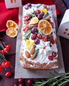 a cake with fruit and nuts on it sitting on a table next to other decorations