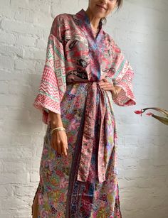 "This is one of a kind patchwork, upcycled silky robe Made free size with wrap tie closing and wide kimono sleeves  Easy and fun to wear around the house or outside as a urban boho style,  flowy kardigan with jeans and tshirt  It is very comfy and feels soft and light  the material is colourful and free flowing  made into this unique stylish over all MEAESURE free size length 55\" MATERIAL *polyester and silk *no lining more boho style ideas available at  https://www.etsy.com/shop/AltheaStores? CARE INSTRUCTIONS  * Wash in warm water * Hand wash recommended * Hang to dry  IMPORTANT NOTE  * Please note that colour shown on your monitor may vary from the colour of the fabric, due to light. If you have any doubts please contact us before purchuase." Multicolor Bohemian Kimono For Home, Spring Robe With Patchwork And Kimono Sleeves, Bohemian Long Sleeve Robe For Home, Bohemian Wrap Robe For Home, Bohemian Silk Robe For Loungewear, Silk Bohemian Robe For Loungewear, Multicolor Patchwork Robe For Spring, Pink Bohemian Kimono For Loungewear, Bohemian Patchwork Robe For Spring