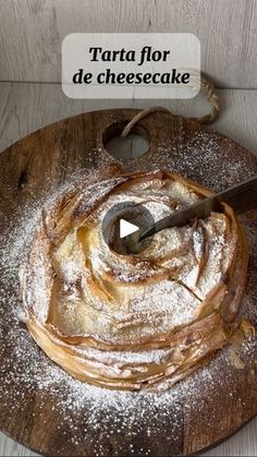 a wooden cutting board topped with powdered sugar next to a knife on top of it