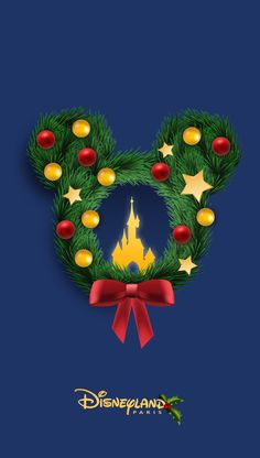 a mickey mouse christmas wreath with lights and decorations on it's ears, in front of a blue background