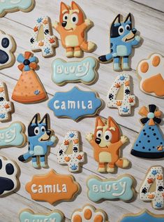 decorated cookies are arranged in the shape of dogs and cats with name tags on them