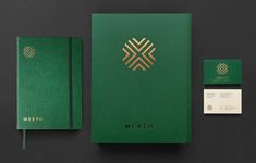 a green and gold stationery set with business cards, notepads and envelope