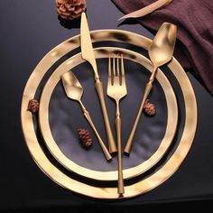 there are forks, spoons and knives on the plate with pine cones around it