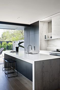 a modern kitchen with an island counter and bar stools