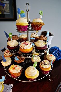 cupcakes are arranged on a three tiered tray