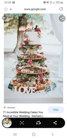 an image of a wedding cake displayed on a tabletop with the word love spelled out