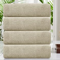 three pieces of beige knitted bedding sitting on top of a table next to a window