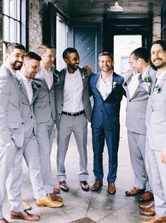 a group of men standing next to each other wearing suits and ties with their arms around one another