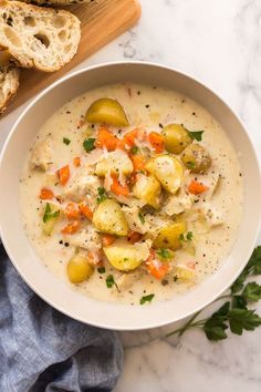 a bowl of potato soup with bread on the side