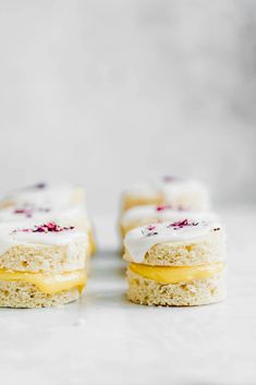 small pastries with frosting on them sitting on top of each other in front of a white background