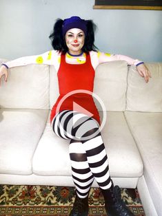 a woman sitting on top of a white couch wearing tights and striped stockings with her legs crossed